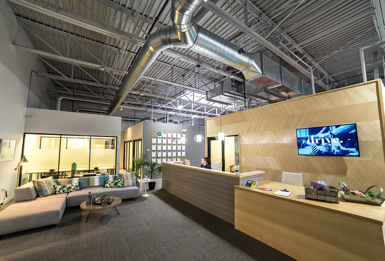 District NHV New Haven - modern reception with wood chevron wall and industrial ceiling