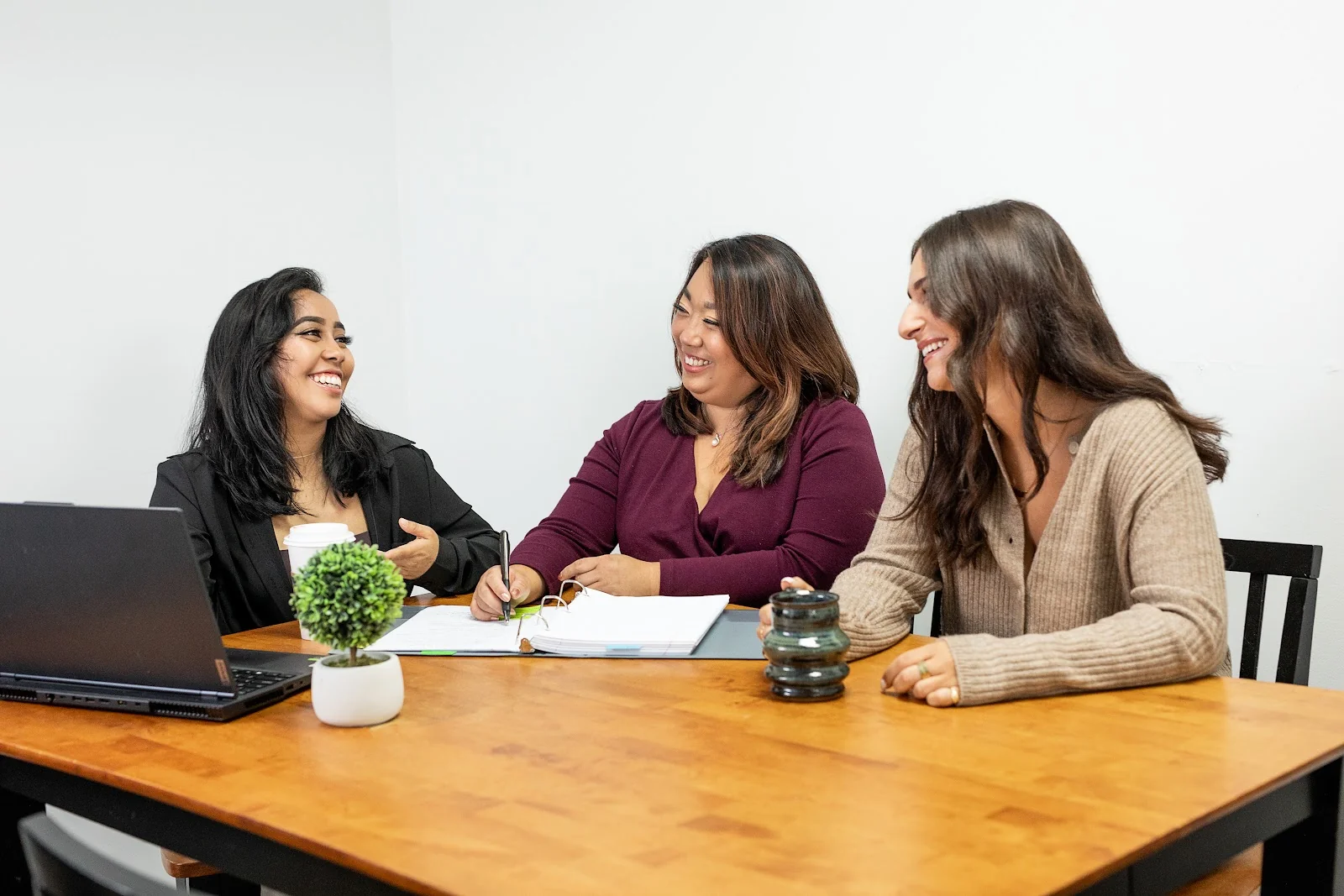 Rose City CoWork Norwich - three professional women collaborating at wooden table