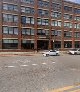 Cultivation Dallas exterior showing a multi-story red brick industrial warehouse building with large grid windows, street-level view on an overcast day