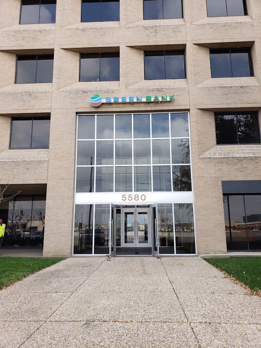 5580 Midtown exterior showing a tan brick multi-story office building with Green Bank signage above the entrance at address 5580, large glass doors, and overcast sky