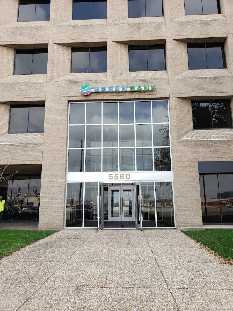 5580 Midtown exterior showing a tan brick multi-story office building with Green Bank signage above the entrance at address 5580, large glass doors, and overcast sky