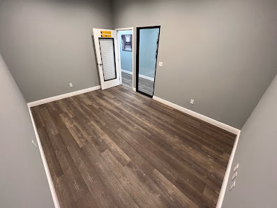 Easy Work Space private office room with dark hardwood floors, gray walls, and glass door entrance