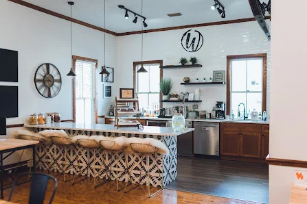 Workspace Collective at Fort King charming kitchen area with patterned tile bar counter, wicker stools, and coffee station