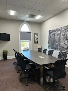 Work Webb conference room with arched gothic window, long dark table, black-and-white city mural, and wall-mounted TV
