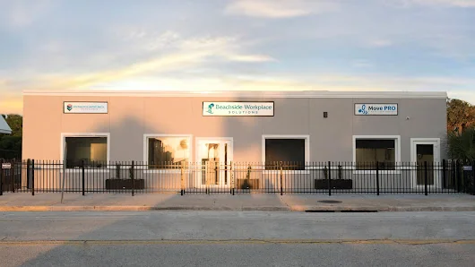 Beachside Workplace Solutions single-story commercial building at sunset with iron fence and business signage