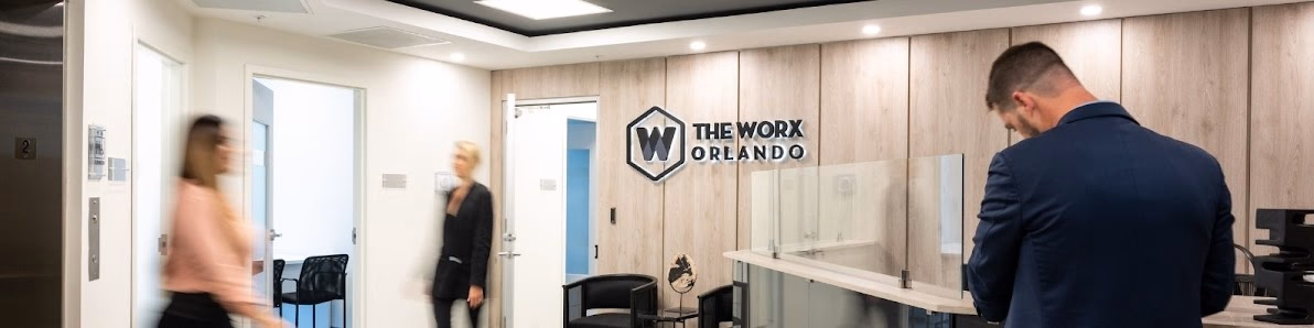 The Worx Offices professional reception area with wood-paneled logo wall and motion-blurred professionals