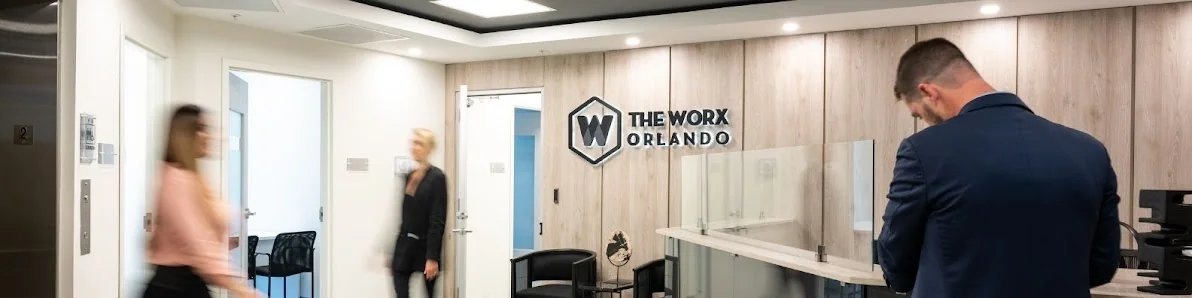 The Worx Offices professional reception area with wood-paneled logo wall and motion-blurred professionals