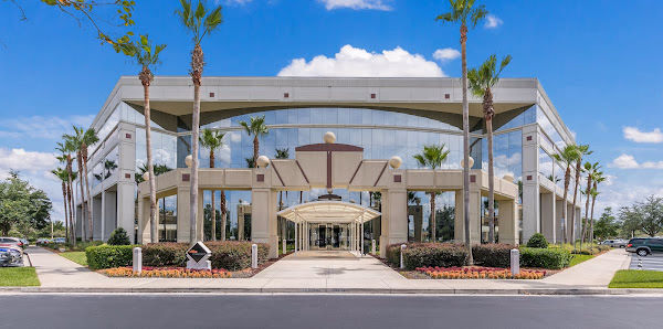 Office Evolution Jacksonville grand glass-fronted commercial building exterior with palm trees and arched entrance