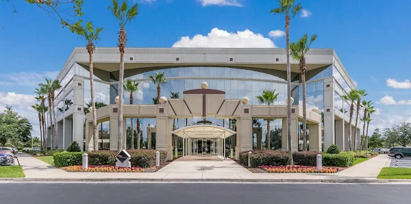 Office Evolution Jacksonville grand glass-fronted commercial building exterior with palm trees and arched entrance