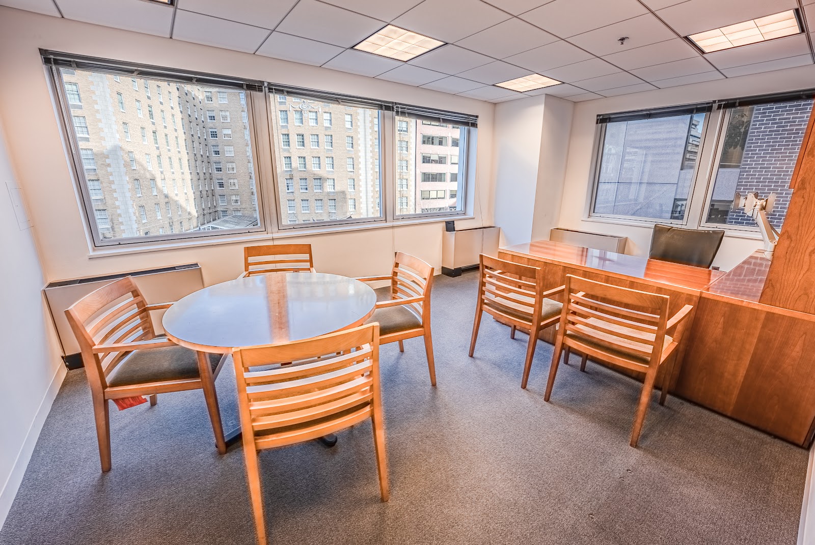 LocalWorks Connecticut Ave traditional meeting room with round wooden table, chairs, and city building views through large windows