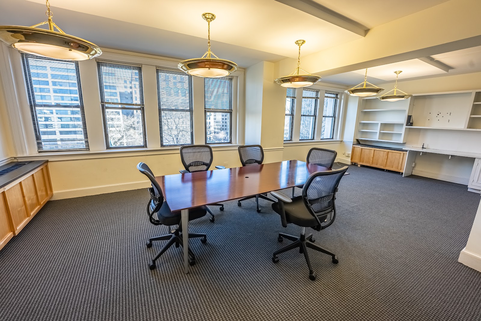 LocalWorks 17th St traditional conference room with cherry wood table, brass pendant light fixtures, mesh chairs, and large windows with city views