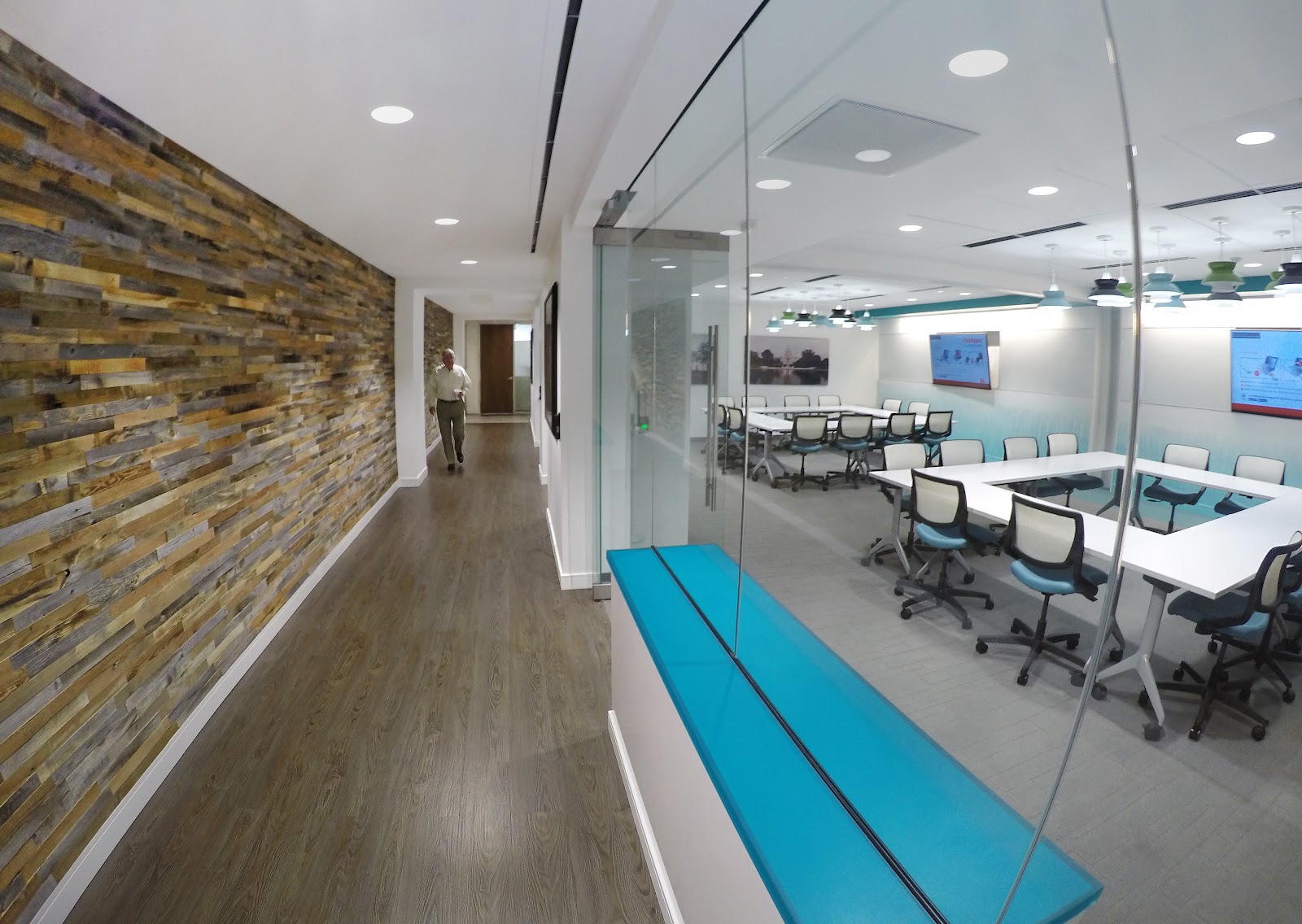 Metro Offices Metro Center featuring reclaimed wood accent wall, glass conference room and teal accents