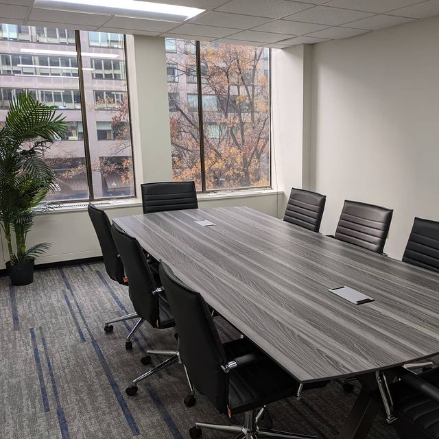 OSI Management conference room with gray wood table, black executive chairs and city views